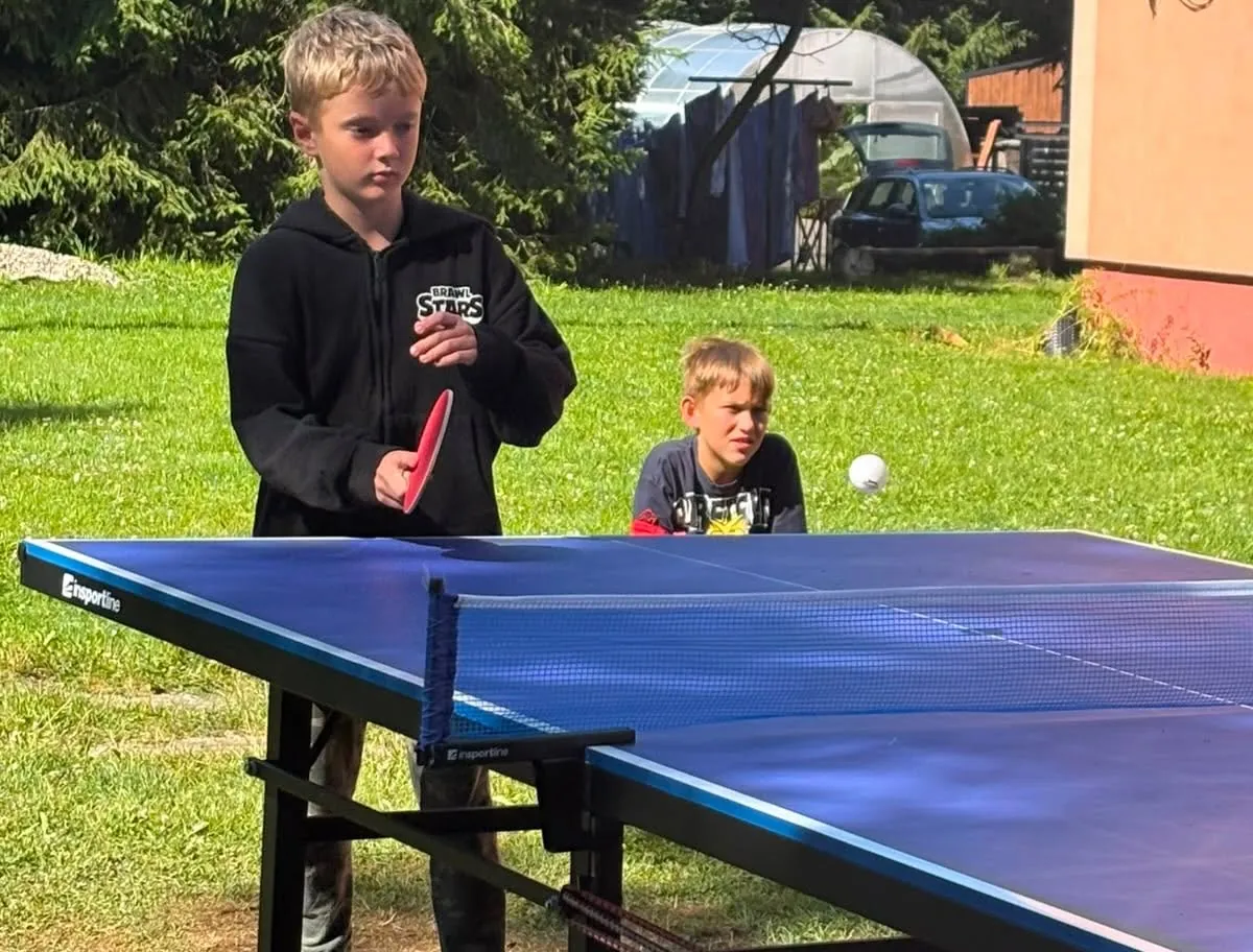 Kluci hrají pingpong na louce u Tábora Kalek